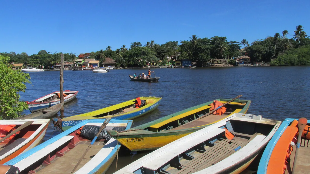 Canoas coloridas alinhadas na margem do Rio Caraíva.